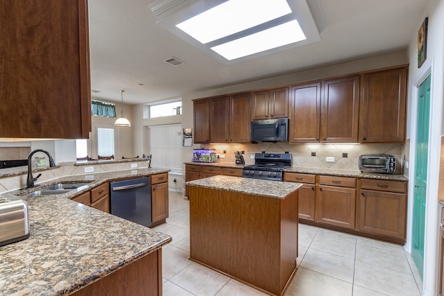 kitchen featuring light tile patterned floors, gas range, a kitchen island, light stone countertops, and dishwasher