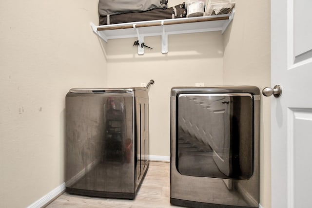 washroom featuring washer and clothes dryer and light hardwood / wood-style floors