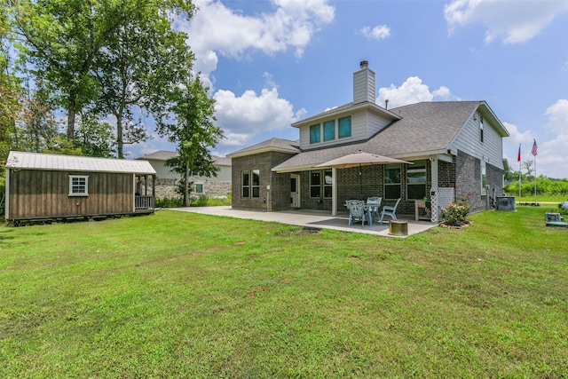 rear view of house featuring a lawn, a patio area, and an outdoor structure