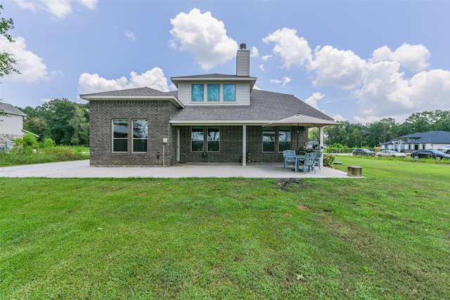 back of house featuring a lawn and a patio area