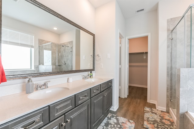 bathroom featuring hardwood / wood-style floors, vanity, and a shower with shower door