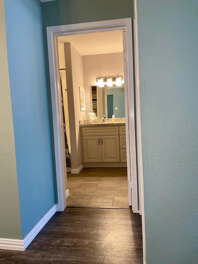 hall with hardwood / wood-style flooring and sink