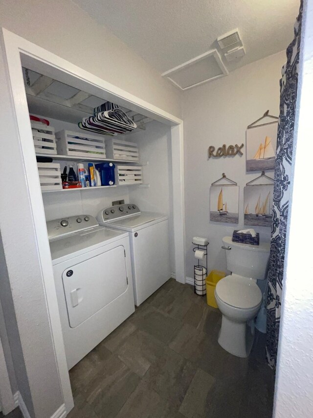 bathroom with washing machine and clothes dryer and toilet