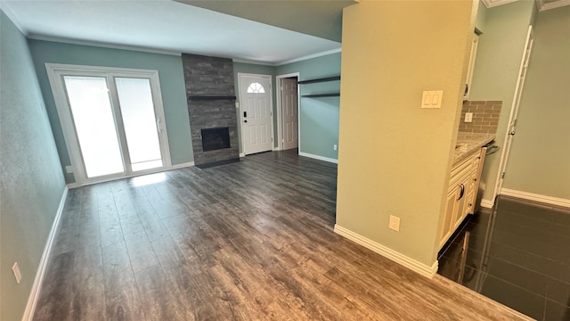 unfurnished living room with crown molding, dark hardwood / wood-style floors, and a fireplace