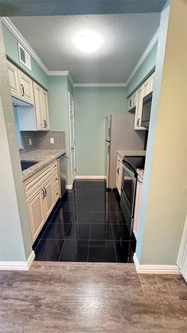 kitchen with appliances with stainless steel finishes, light stone counters, ornamental molding, dark hardwood / wood-style flooring, and decorative backsplash