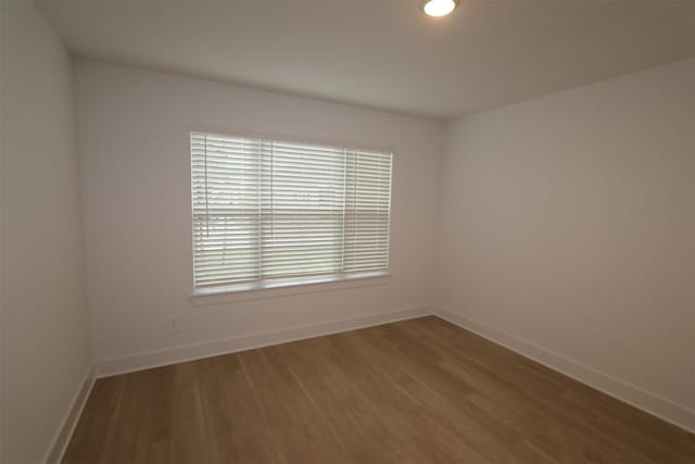 empty room with hardwood / wood-style floors and a wealth of natural light