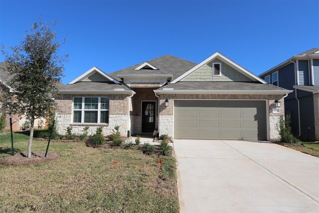 craftsman inspired home with a garage and a front lawn