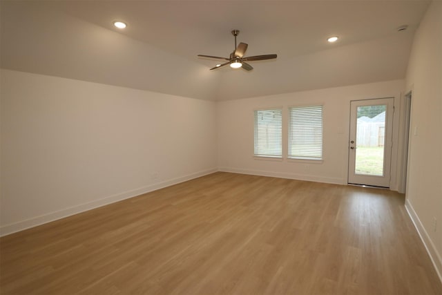 spare room featuring vaulted ceiling, ceiling fan, and light wood-type flooring