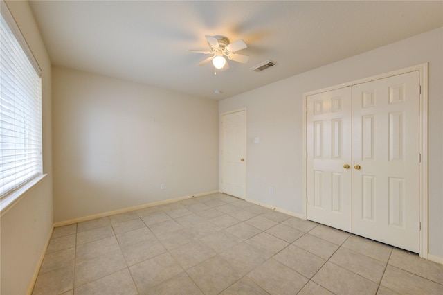 unfurnished bedroom with ceiling fan, a closet, and light tile patterned floors