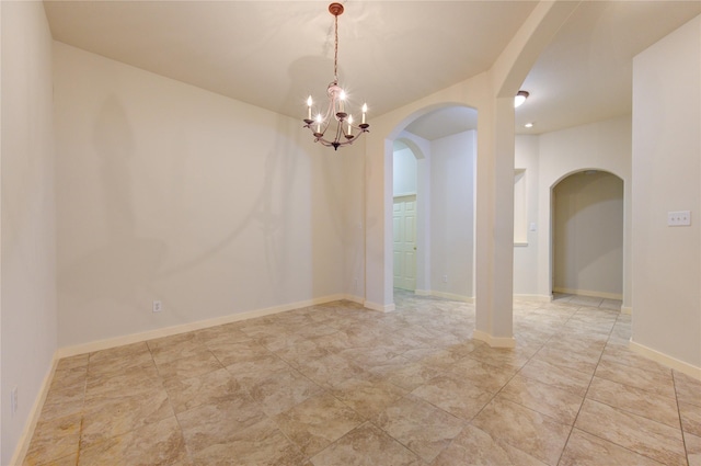 spare room with a notable chandelier