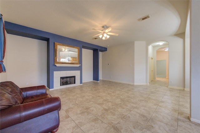 living room with a fireplace, light tile patterned floors, and ceiling fan