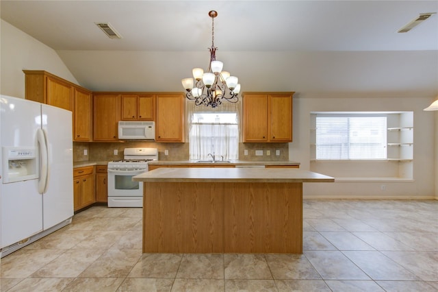 kitchen featuring a notable chandelier, a kitchen island, white appliances, and sink