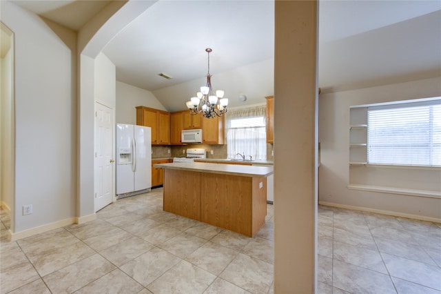 kitchen featuring a notable chandelier, pendant lighting, vaulted ceiling, white appliances, and a kitchen island