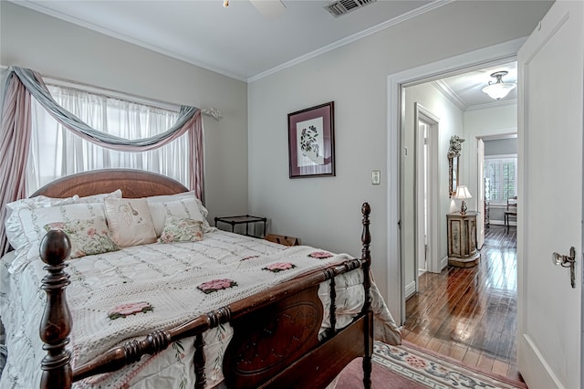 bedroom with hardwood / wood-style flooring, crown molding, and ceiling fan