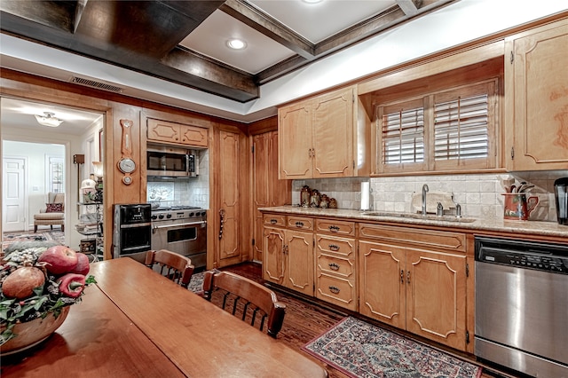 kitchen featuring dark wood-type flooring, coffered ceiling, appliances with stainless steel finishes, decorative backsplash, and sink