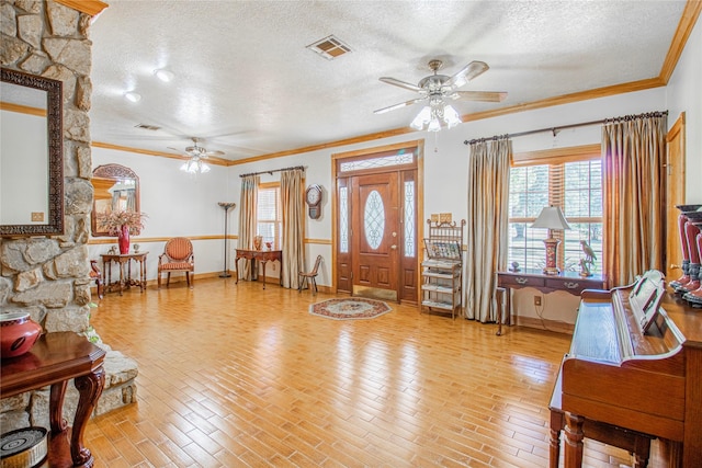 foyer featuring ceiling fan, light hardwood / wood-style flooring, a textured ceiling, and crown molding