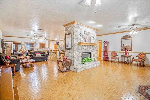 living room with a fireplace, ceiling fan, and crown molding