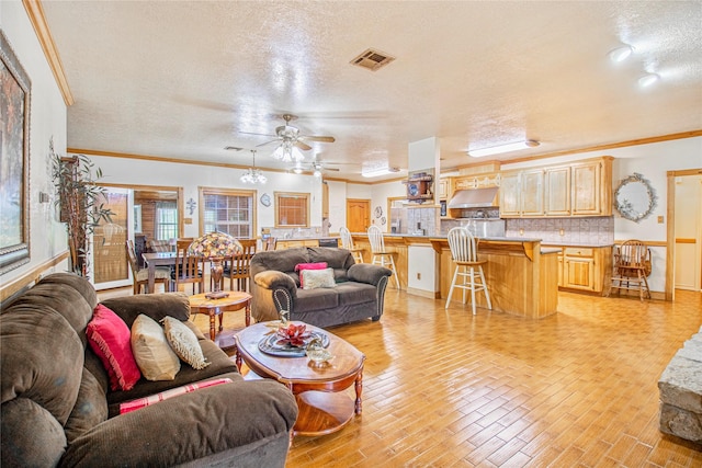 living room with ceiling fan, a textured ceiling, light hardwood / wood-style flooring, and crown molding