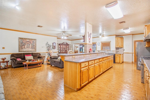 kitchen featuring backsplash, high end range, light hardwood / wood-style floors, and crown molding