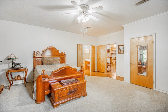 bedroom with ornamental molding, ceiling fan, light colored carpet, and a textured ceiling