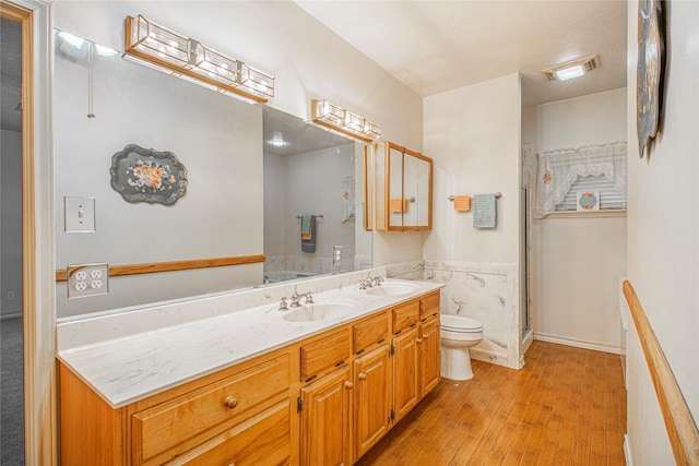 bathroom featuring a shower with door, wood-type flooring, toilet, and vanity