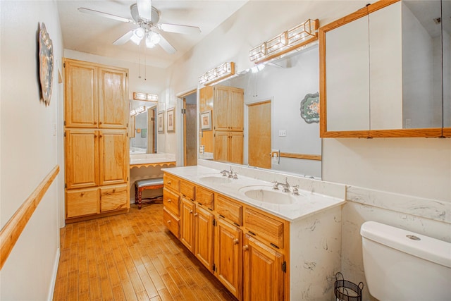 bathroom featuring ceiling fan, hardwood / wood-style floors, toilet, and vanity