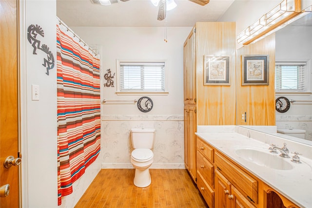 bathroom with hardwood / wood-style floors, a healthy amount of sunlight, toilet, and vanity