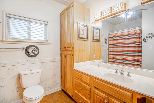 bathroom with a shower with curtain, hardwood / wood-style flooring, toilet, and vanity