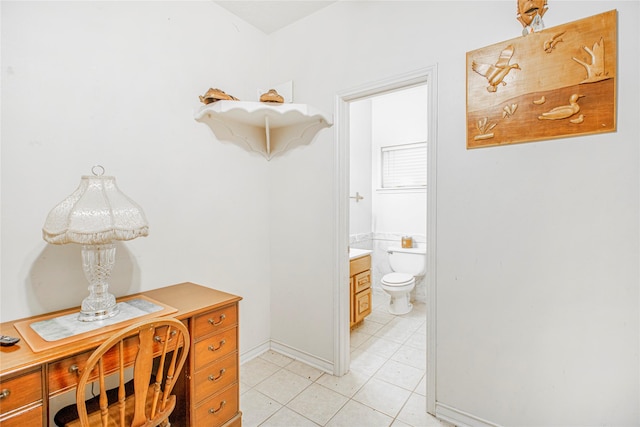 bathroom with toilet, vanity, and tile patterned flooring