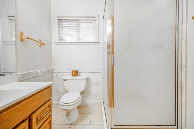 bathroom with an enclosed shower, vanity, toilet, and tile patterned flooring