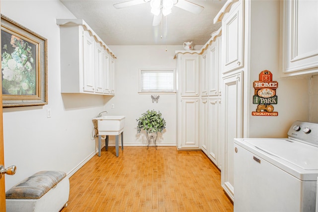 laundry area with light wood-type flooring, ceiling fan, washer / dryer, and cabinets