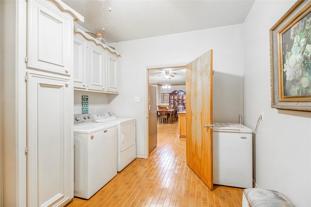 washroom featuring cabinets, washer and dryer, and light hardwood / wood-style floors