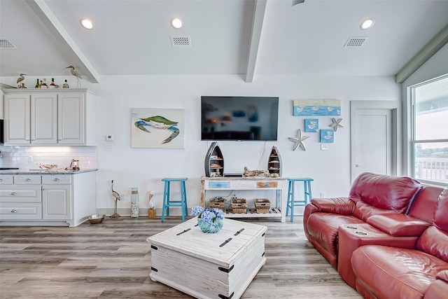 living room featuring beam ceiling and light wood-type flooring