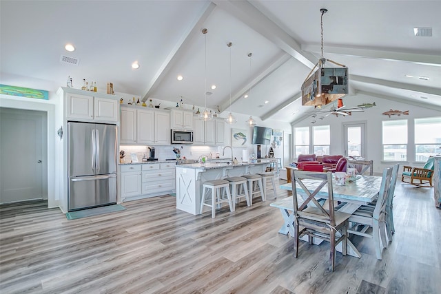 dining room featuring ceiling fan, light wood-type flooring, beamed ceiling, and high vaulted ceiling