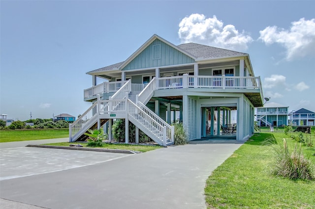 view of front of property with covered porch, a front yard, and a carport