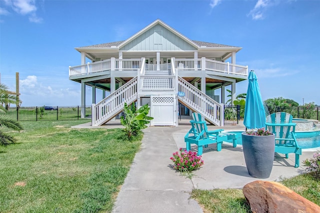 view of front of house with a wooden deck, a front lawn, and a patio