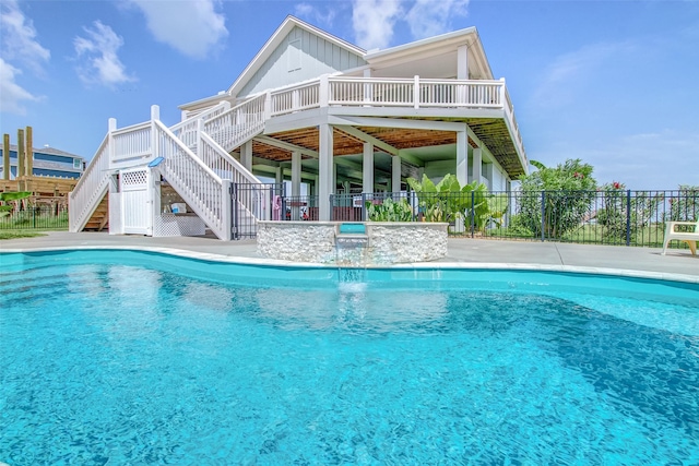 view of pool with a wooden deck, a hot tub, and pool water feature