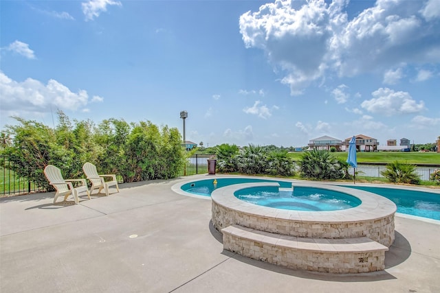 view of pool featuring a water view, a patio, and an in ground hot tub