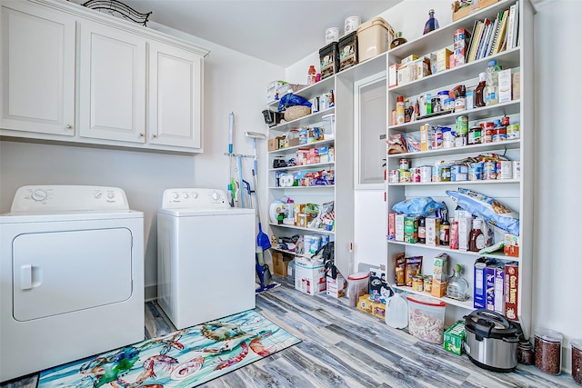 laundry area with washer and dryer, cabinets, and light wood-type flooring