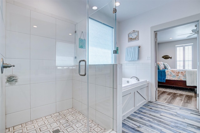 bathroom featuring ceiling fan, wood-type flooring, tile walls, and plus walk in shower