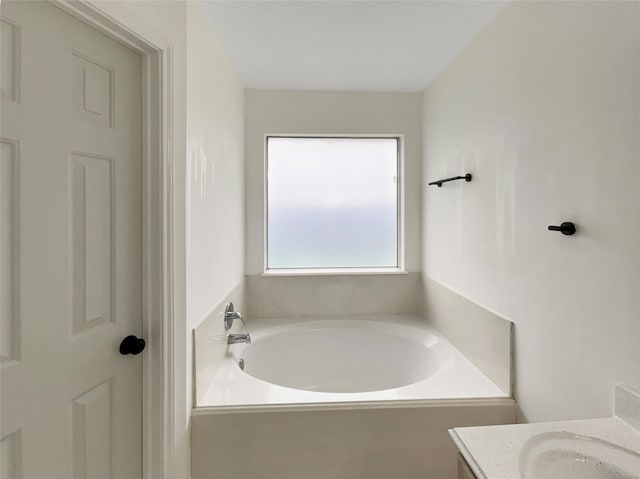 bathroom with vanity and a tub