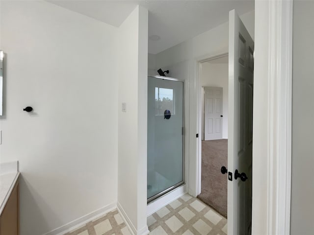 bathroom featuring a shower with door, vanity, and tile patterned flooring