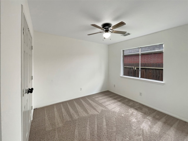 carpeted spare room featuring ceiling fan