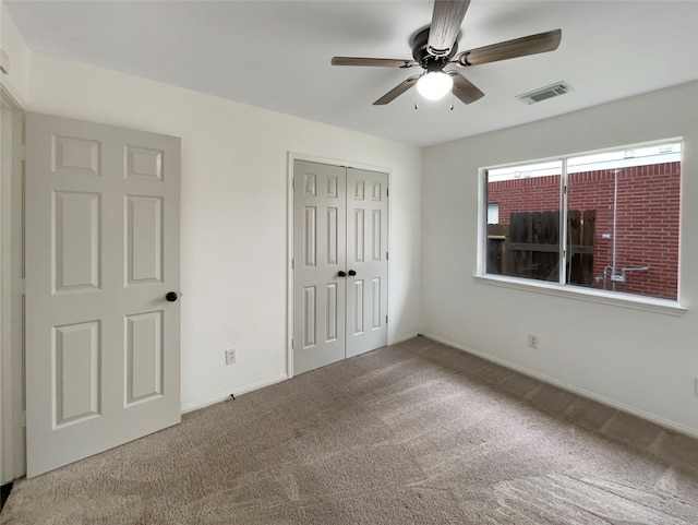 unfurnished bedroom featuring ceiling fan, carpet flooring, and a closet