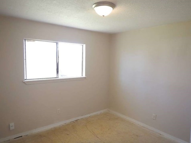 unfurnished room featuring a textured ceiling