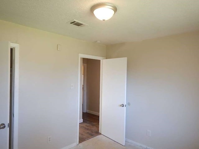 unfurnished bedroom with hardwood / wood-style floors and a textured ceiling