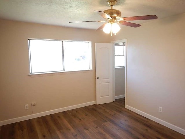 empty room featuring ceiling fan and dark hardwood / wood-style flooring