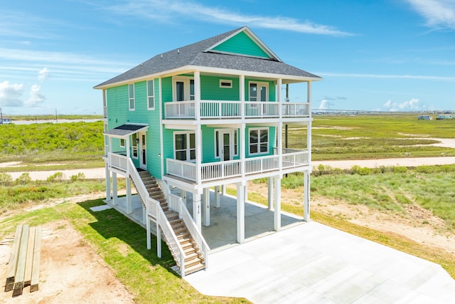 rear view of property featuring a porch and a rural view