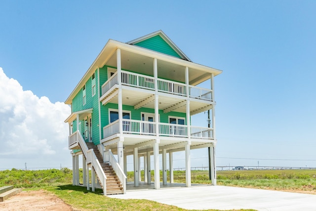 view of front facade with a balcony, a carport, and a porch