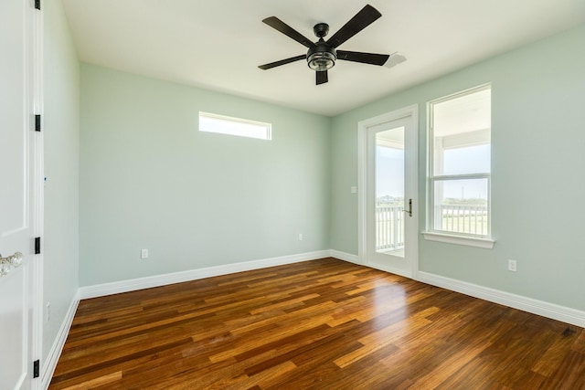 empty room with ceiling fan and dark wood-type flooring